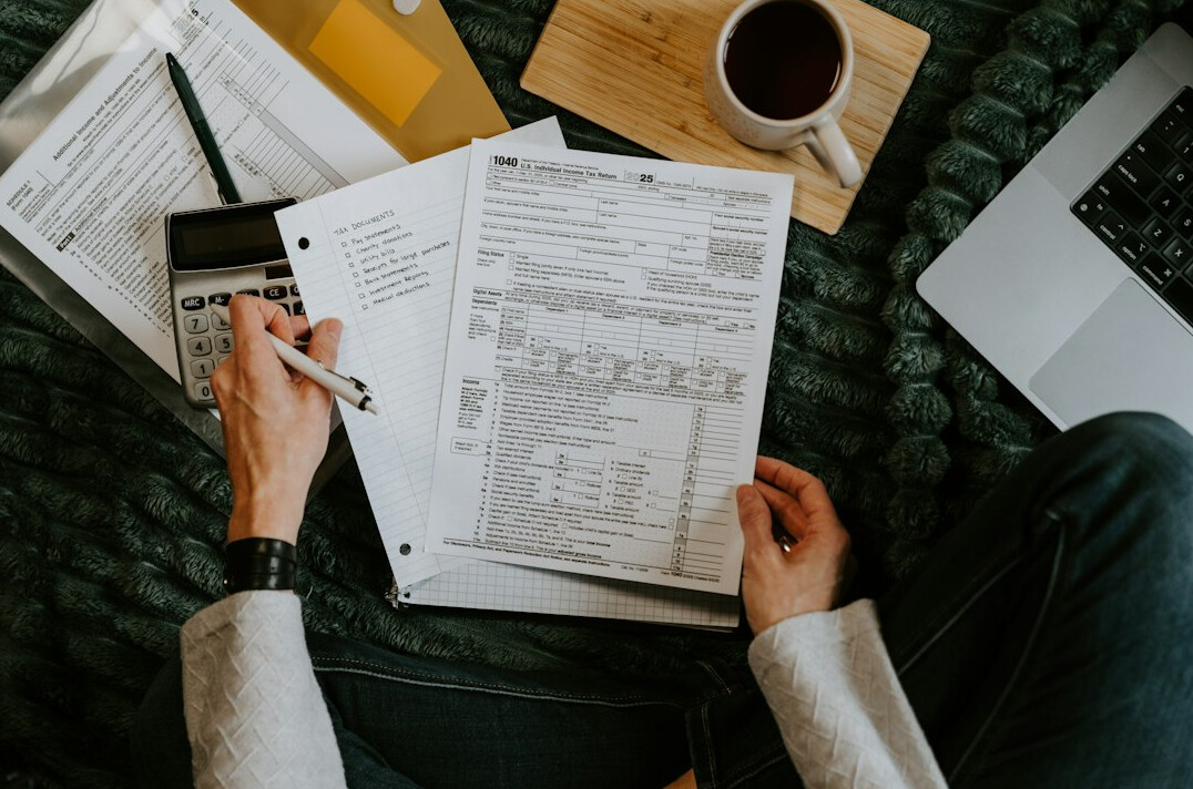 person calculating expenses on laptop
